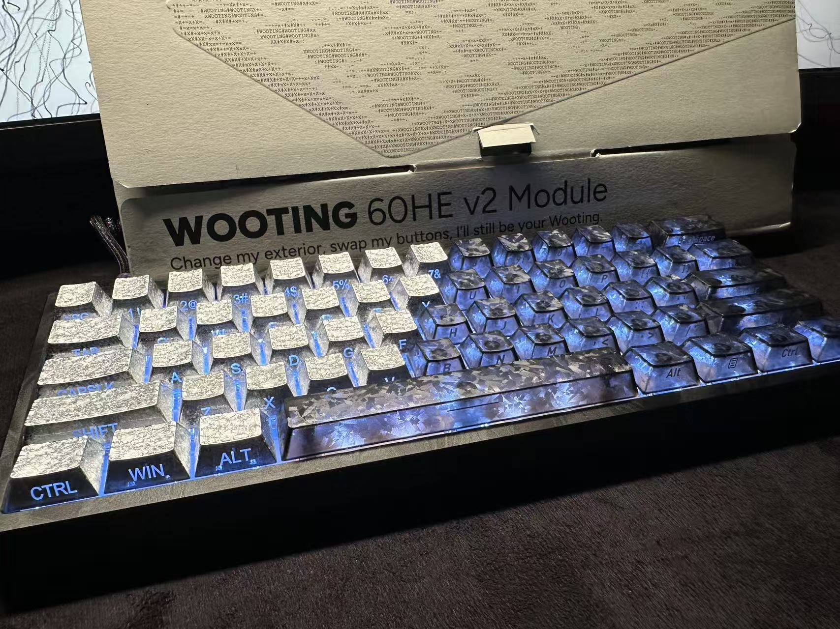 Wooting 60HE V2 keyboard with blue backlighting and textured silver keycaps