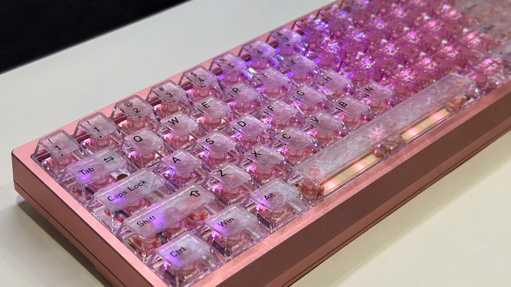 Pink keyboard with transparent keycaps and purple lighting